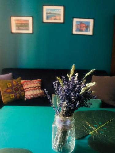 a vase of flowers on a table in a living room at Lawendowo- sauna, basen, domki w ogrodzie i apartamenty w kamienicy in Sandomierz
