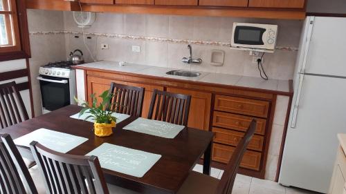 una cucina con tavolo con sedie e frigorifero di Casita Playa Mansa a Punta del Este