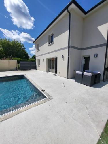 une maison avec une piscine à côté d'un bâtiment dans l'établissement maison avec piscine, à Saint-Médard-en-Jalles
