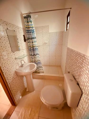 une salle de bain avec toilettes et lavabo dans l'établissement O galpão Casa Flor, à Vale do Capão