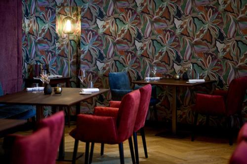 a restaurant with two tables and chairs and a floral wallpaper at Hotel Weisser Bär in St. Wolfgang