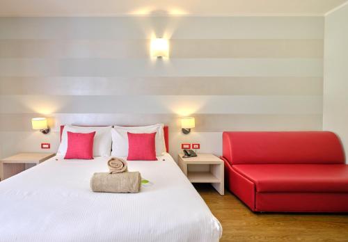 a bedroom with a bed and a red couch at Hotel Eden Garda in Garda