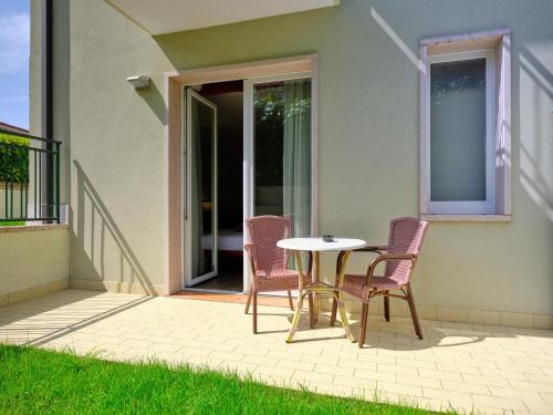 a patio with a table and chairs on a patio at Hotel Eden Garda in Garda