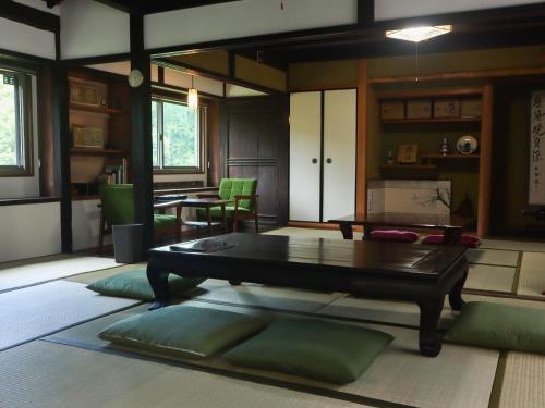 a living room with a table and green pillows at Mizuma no Yado - Vacation STAY 16613v in Kaizuka