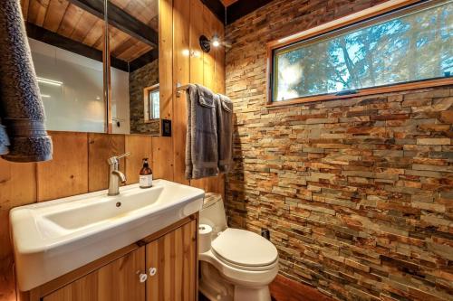 a bathroom with a sink and a brick wall at A-frame Escape Unique Stay W Comfort & Style in Shaver Lake