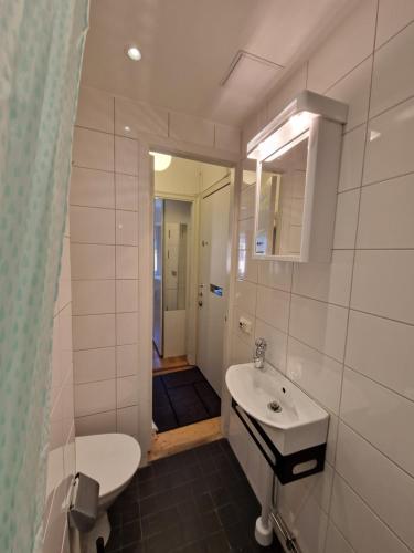 a bathroom with a sink and a toilet and a mirror at Home Inn Rör11 in Stockholm