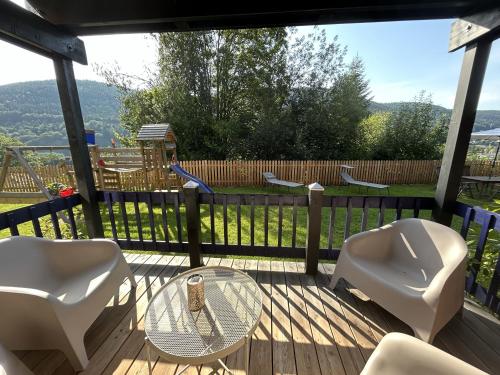 a deck with chairs and a glass table and chairs at Ferienwohnung Kuckucksnest in Bad Wildbad