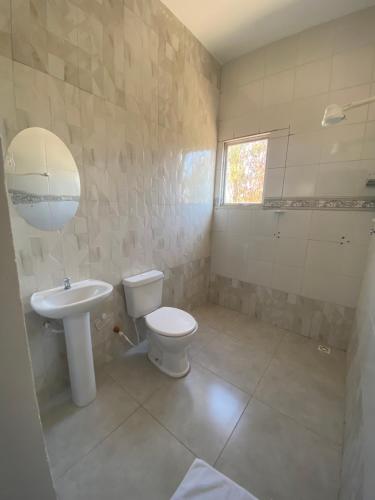 a bathroom with a toilet and a sink at Hotel Pousada Do Sol II in Aragarças