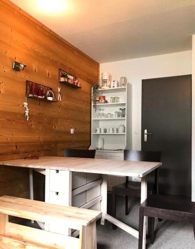 Cette chambre est dotée d'un mur en bois avec une table et des chaises. dans l'établissement Résidence Les Charmettes - Deux pièces confort MAE-4394, à Aime La Plagne