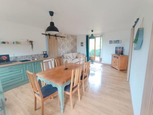 une cuisine et une salle à manger avec une table et des chaises en bois dans l'établissement Le chalet du lilas, à Liessies