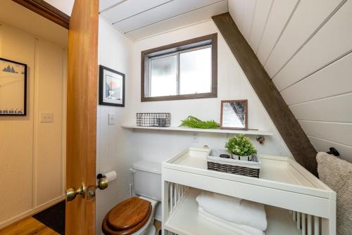 ein Badezimmer mit Toilette und Fenster in der Unterkunft Dogwood Peak Mid-century A-frame With Ac Style in Shaver Lake