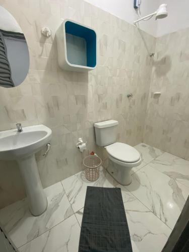 a white bathroom with a sink and a toilet at Hotel Pousada Do Sol II in Aragarças