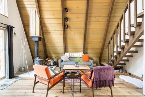 ein Wohnzimmer mit Sofa und Tisch in der Unterkunft Dogwood Peak Mid-century A-frame With Ac Style in Shaver Lake