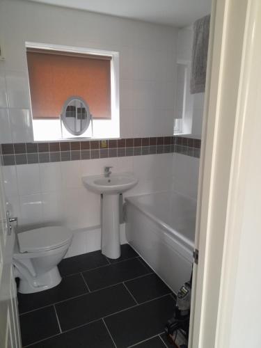 a bathroom with a sink and a toilet and a bath tub at clifftop villa 47 in Corton