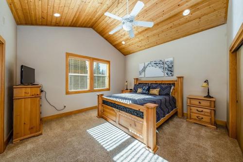 ein Schlafzimmer mit einem Bett und einem Deckenventilator in der Unterkunft Sierra Pines Villa Deck Jetted Tub Game Rm in Shaver Lake