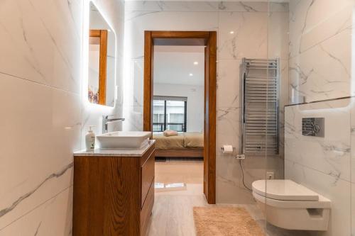 a bathroom with a sink and a toilet and a mirror at Spacious - Beautiful - Sea Front in Sliema