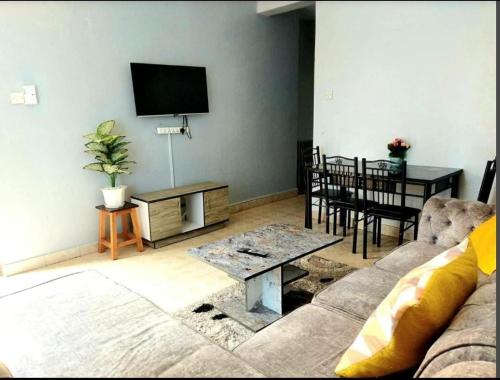 a living room with a couch and a flat screen tv at Little Haven Nyali mombasa in Mombasa