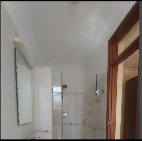 a bathroom with a shower and a glass door at Little Haven Nyali mombasa in Mombasa