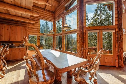 comedor con mesa y algunas ventanas en Waterfall Lodge Yellowstone Vibes Ac Space, en Shaver Lake