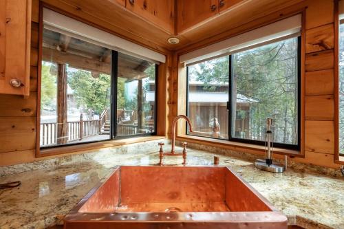 Una cocina con un gran fregadero de cobre y ventanas. en Waterfall Lodge Yellowstone Vibes Ac Space, en Shaver Lake