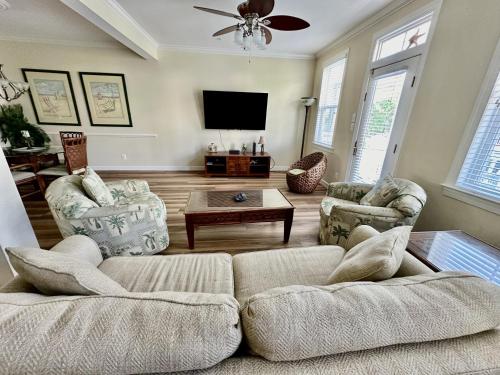 a living room with a couch and a tv at Sunset Island - 35 Seaside in Ocean City