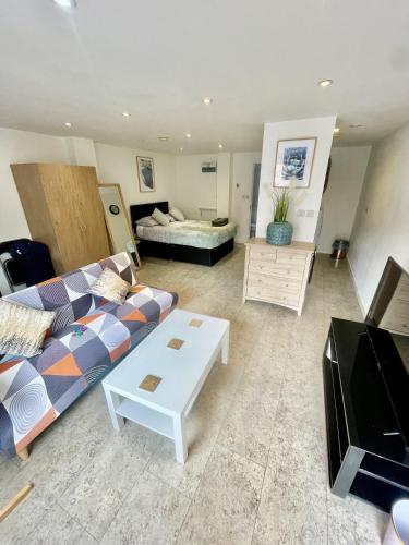 un soggiorno con un divano e una TV di Studio - Sleeps 2 - Parking - Wifi a Cambridge