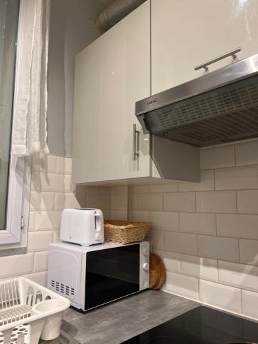 une cuisine avec un four micro-ondes sur un comptoir dans l'établissement Maison bleue, à Noisy-le-Sec