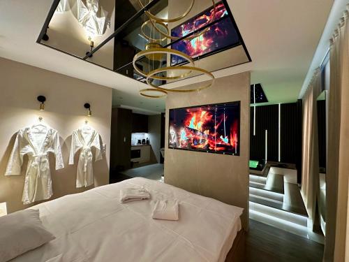 a bedroom with a white bed and a tv on the wall at Masarska 8 VIP Apartamenty JACUZZI in Kraków