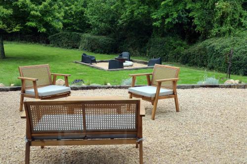 two chairs and a table in a garden with a fire pit at Casa del molí in Sarp
