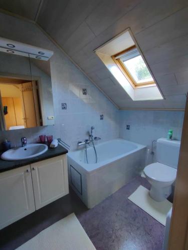 a bathroom with a tub and a toilet and a sink at Duinzicht in Koksijde