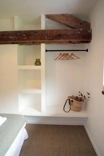 a bedroom with a bed and a white wall at Casa del molí in Sarp