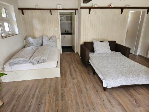 a bedroom with two beds and a couch at Ferienhaus Rhön-Auszeit in Bischofsheim an der Rhön