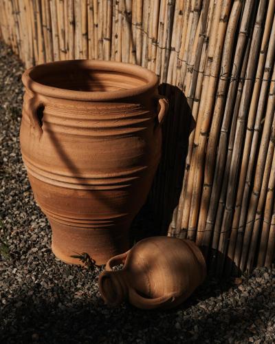 a clay vase sitting next to a wooden fence at AMÉNTE Mindful Stay in Plakias