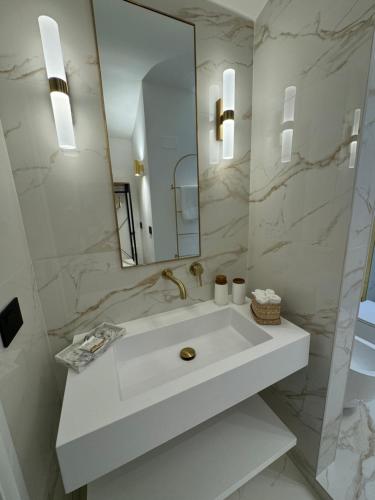 a white bathroom with a sink and a mirror at Cloè Boutique Apartment in Termoli