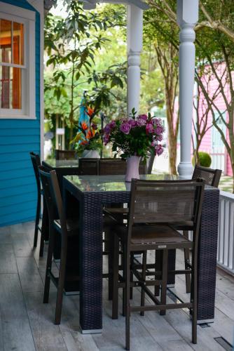 a table and chairs on a porch with purple flowers at Amazing Modern Property 5 BR Next to French QT & Bourbon in New Orleans