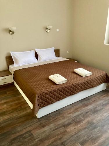 a bedroom with a large bed with two towels on it at Balkan Aparts in Hisarya
