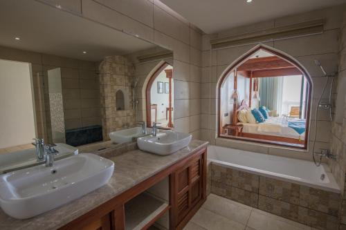 a bathroom with two sinks and a large mirror at Shukran Palace in Pingwe