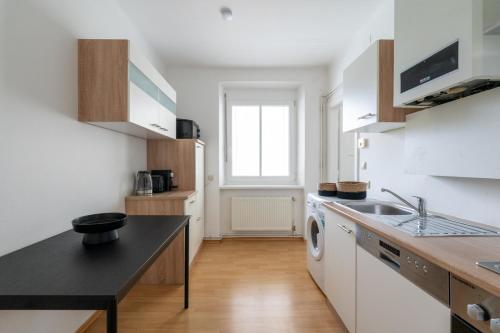 a kitchen with a sink and a washing machine at FarawayHomes Studio Leoben #A6 in Leitendorf