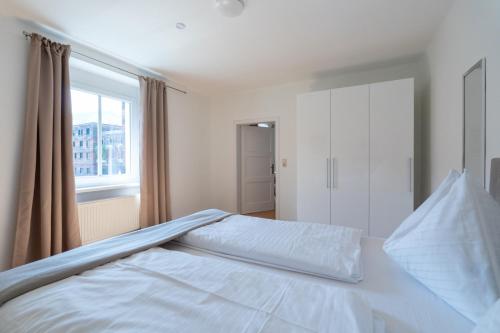a white bed in a bedroom with a window at FarawayHomes Studio Leoben #A6 in Leitendorf