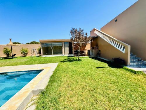 a backyard with a swimming pool and a house at DAR MAÏSSA in Asilah