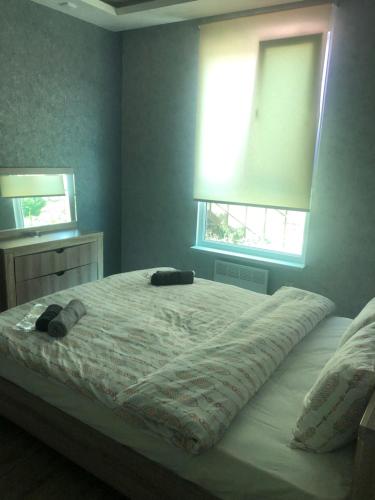 a bedroom with a large bed with two windows at Villa Maria Dilijan in Dilijan