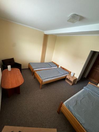 a room with two beds and a table at Penzion a restaurace U Knoppa in Opava