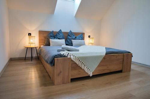 a bedroom with a large wooden bed with two lamps at Apartmány U Zajíců in Karlov