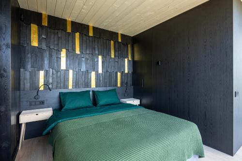 a bedroom with a green bed and a wall at VyriY House in Lis