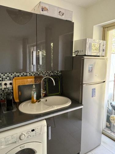 une cuisine avec un évier et un réfrigérateur dans l'établissement 2 Pièces au cœur de Cagnes Sur Mer, à Cagnes-sur-Mer