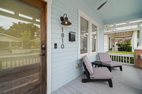 a porch with two chairs and a table and a door at NEW! Casa Fuente - Beautifully Renovated Ybor Bungalow, Steps to 7th Ave in Tampa