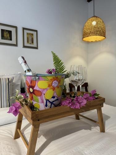 a vase on a wooden table with a wine glass at casa lumka hotel boutique spa in Mariquita
