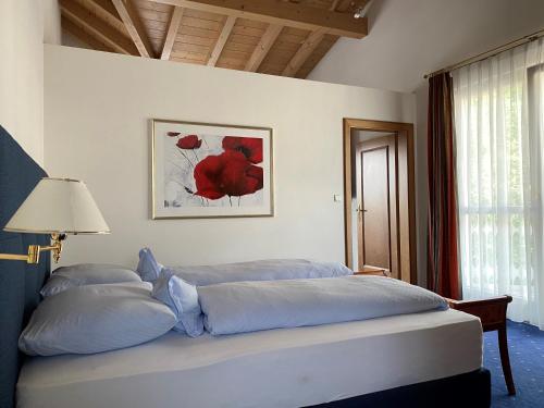a bedroom with a bed with blue sheets and a window at Boutique-Hotel Ballguthof am Golfplatz in Lana