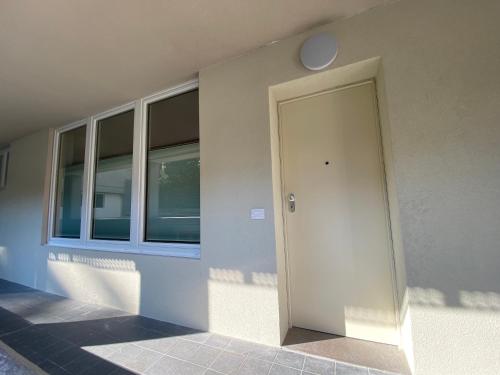 a white door on the side of a building at NEW Residenza le Essenze - i 7 Laghi in Erba