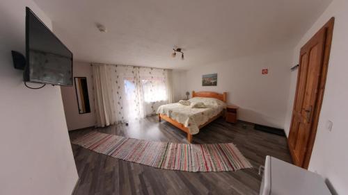a bedroom with a bed and a flat screen tv at Simon House in Şimon
